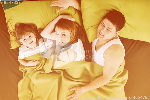 Image of happy family relaxing in bed