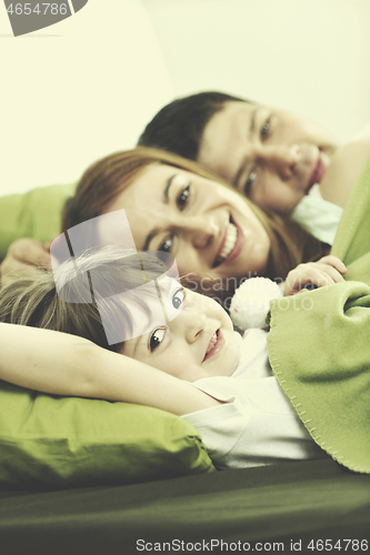 Image of happy family relaxing in bed