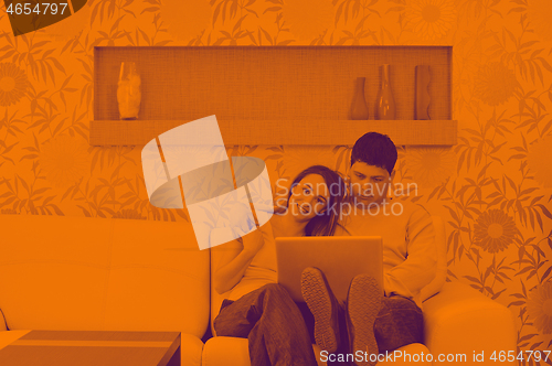 Image of young couple working on laptop at home