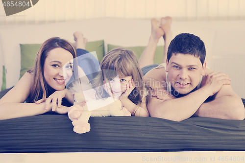 Image of happy family relaxing in bed