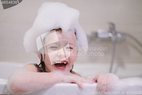 Image of little girl in bath playing with soap foam