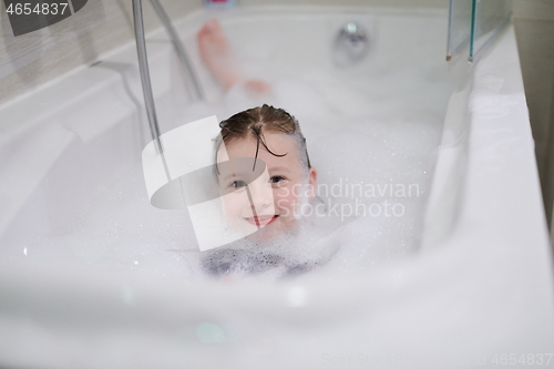 Image of little girl in bath playing with soap foam