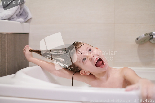 Image of little girl in bath playing with soap foam