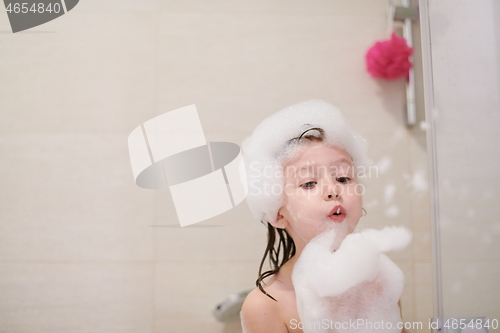 Image of little girl in bath playing with soap foam