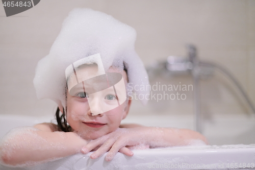 Image of little girl in bath playing with soap foam