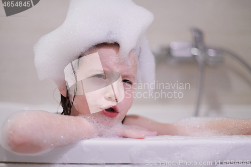 Image of little girl in bath playing with soap foam