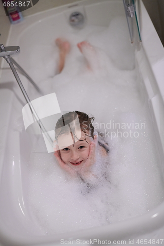 Image of little girl in bath playing with soap foam