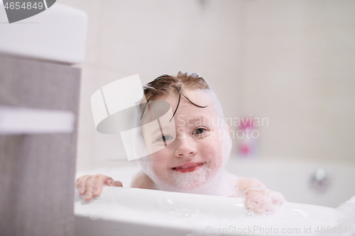 Image of little girl in bath playing with soap foam