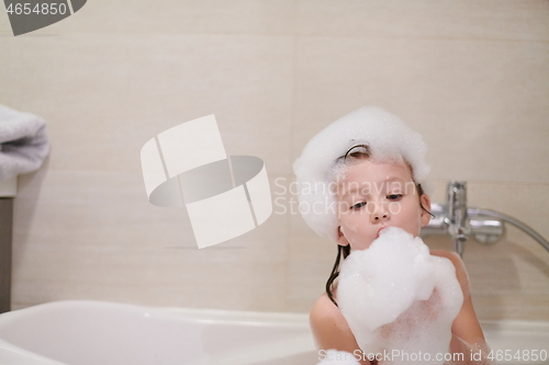 Image of little girl in bath playing with soap foam