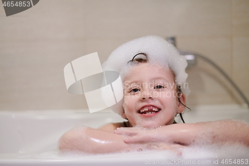 Image of little girl in bath playing with soap foam