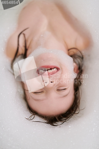 Image of little girl in bath playing with soap foam