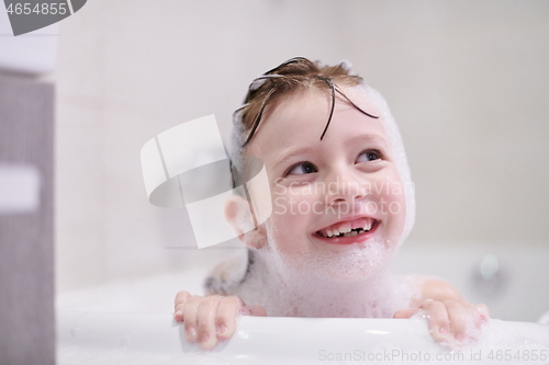 Image of little girl in bath playing with soap foam