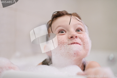 Image of little girl in bath playing with soap foam