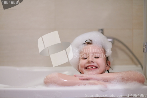 Image of little girl in bath playing with soap foam