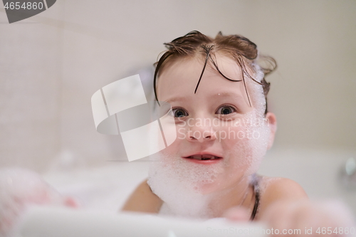 Image of little girl in bath playing with soap foam