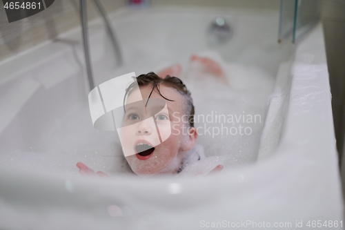 Image of little girl in bath playing with soap foam