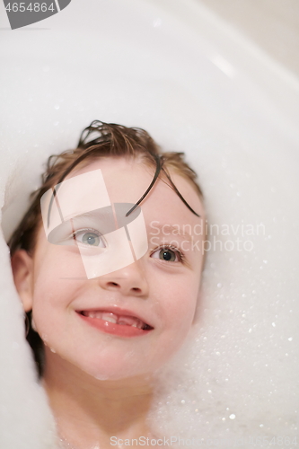 Image of little girl in bath playing with soap foam