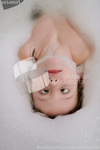 Image of little girl in bath playing with soap foam