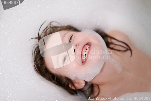 Image of little girl in bath playing with soap foam