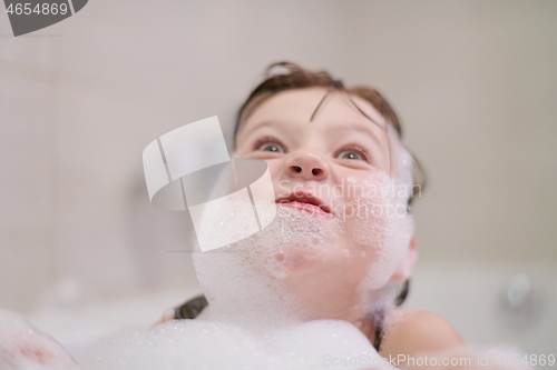 Image of little girl in bath playing with soap foam