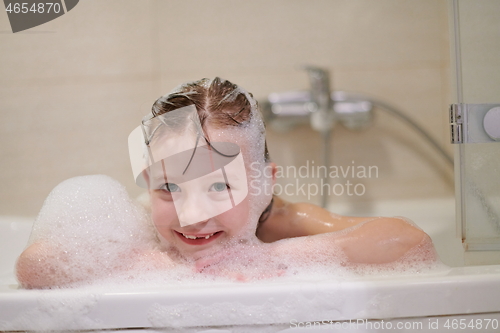 Image of little girl in bath playing with soap foam