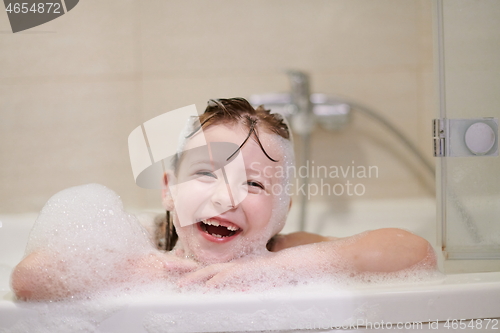 Image of little girl in bath playing with soap foam