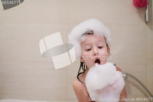 Image of little girl in bath playing with soap foam