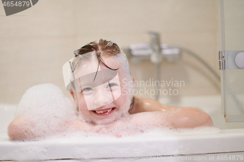 Image of little girl in bath playing with soap foam