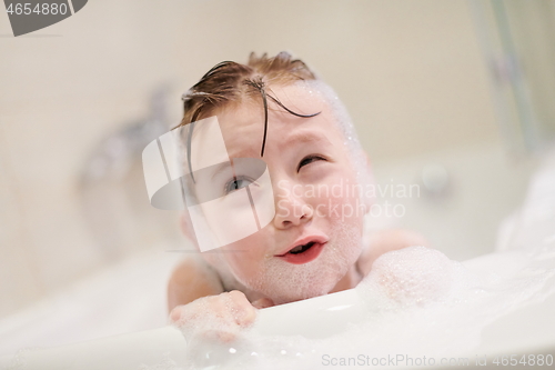 Image of little girl in bath playing with soap foam