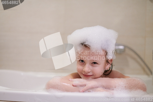 Image of little girl in bath playing with soap foam