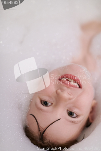 Image of little girl in bath playing with soap foam