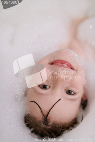 Image of little girl in bath playing with soap foam