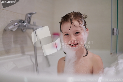 Image of little girl in bath playing with soap foam