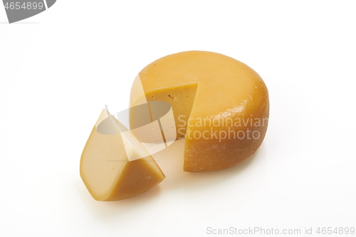 Image of whole round and one peace of organic produced cheese