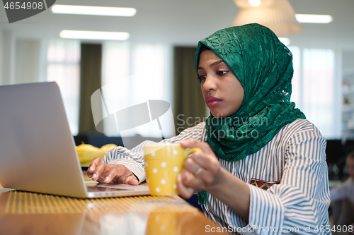 Image of african muslim business woman drinking tea