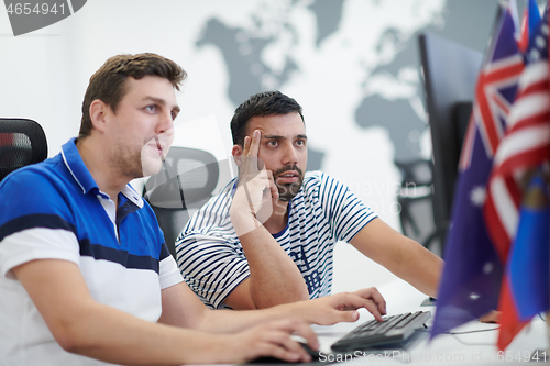 Image of two male software developers working on computer