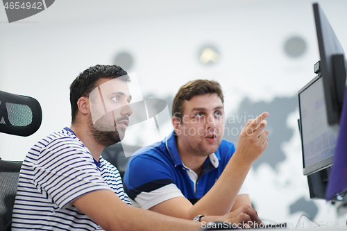 Image of two male software developers working on computer