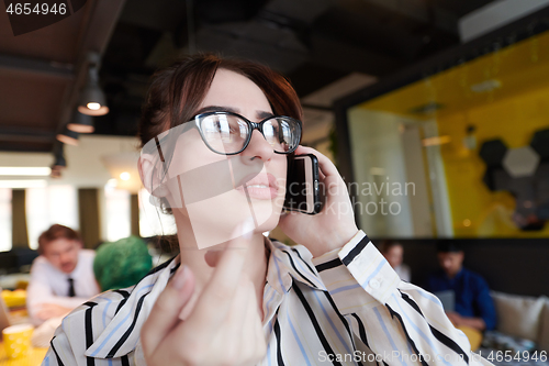 Image of portrait of businesswoman with glasses using mobile phone