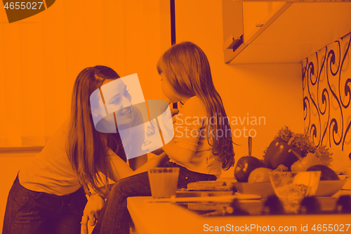 Image of happy daughter and mom in kitchen