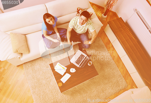 Image of young couple working on laptop at home