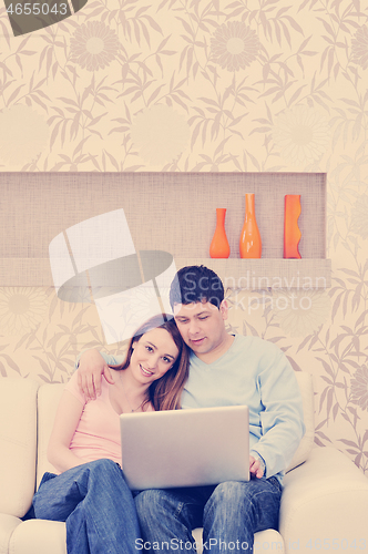 Image of young couple working on laptop at home