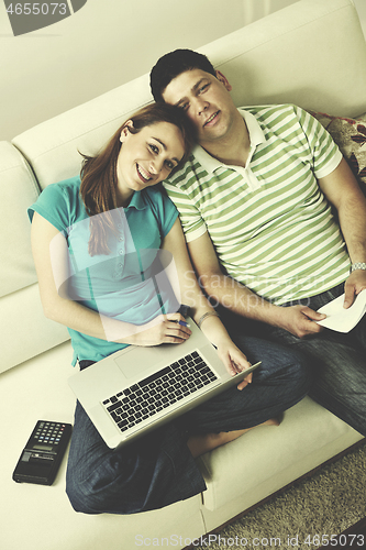 Image of young couple working on laptop at home