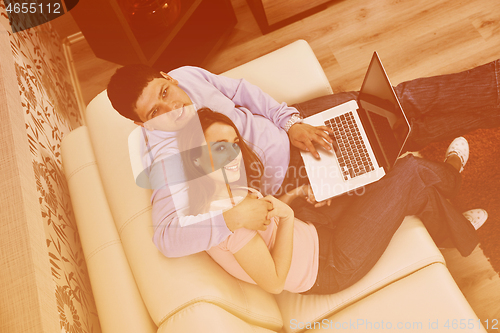 Image of young couple working on laptop at home