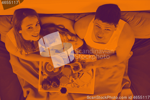 Image of happy young family eat breakfast in bed