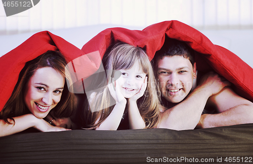 Image of happy family relaxing in bed