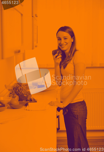 Image of happy young  woman with apple in kitchen