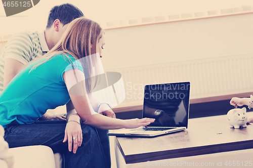 Image of young couple working on laptop at home