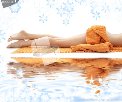 Image of long legs of relaxed lady with orange towel