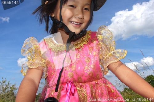 Image of Cute girl cycling with a princess outfit