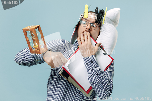 Image of Tired man sleeping at home having too much work. Bored businessman with pillow